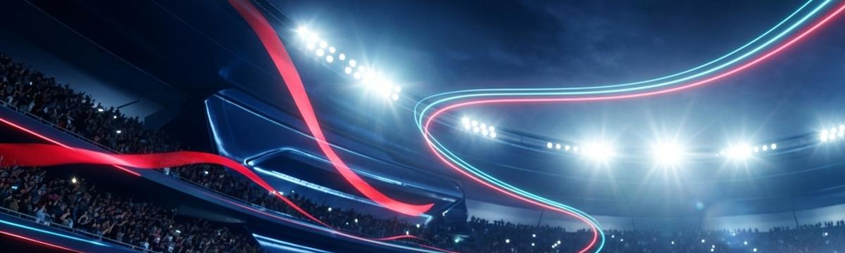 Fußballstadion bei Flutlicht mit Ball auf dem Rasen und Fans auf den Rängen